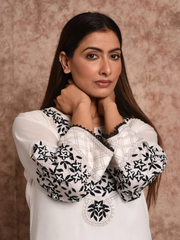 Close-up portrait highlighting black floral sleeve embroidery and yoke motifs on Elara ivory kurta by Embrowhite