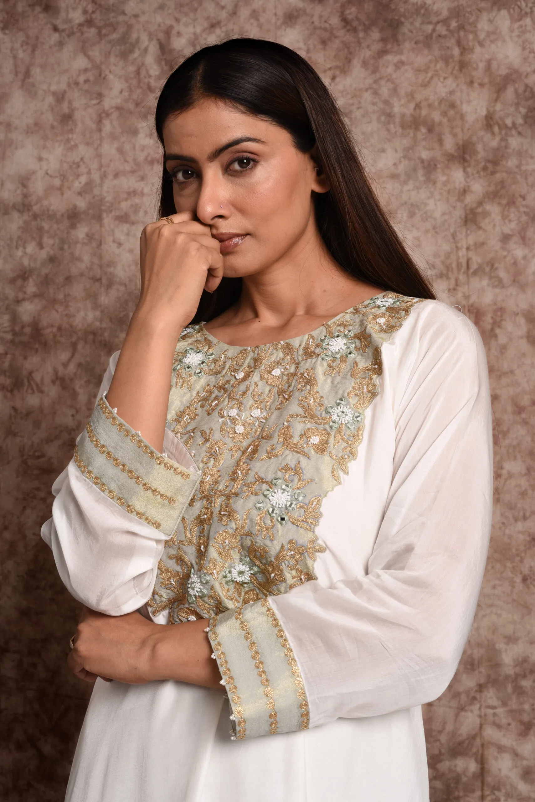 Close-up portrait view of Verbena suit top detailing gold threadwork bib neckline and embroidered cuff sleeve borders by Embrowhite Close-up portrait view of Verbena suit top detailing gold threadwork bib neckline and embroidered cuff sleeve borders by Embrowhite