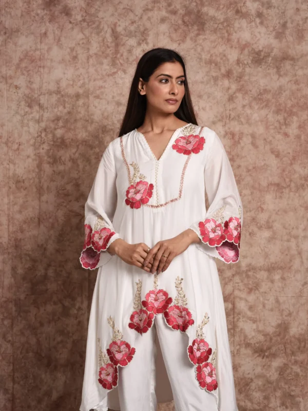 Close-up view of pink floral embroidery and gold threadwork on V-neck yoke and bell sleeves of Roselle ivory kurta by Embrowhite