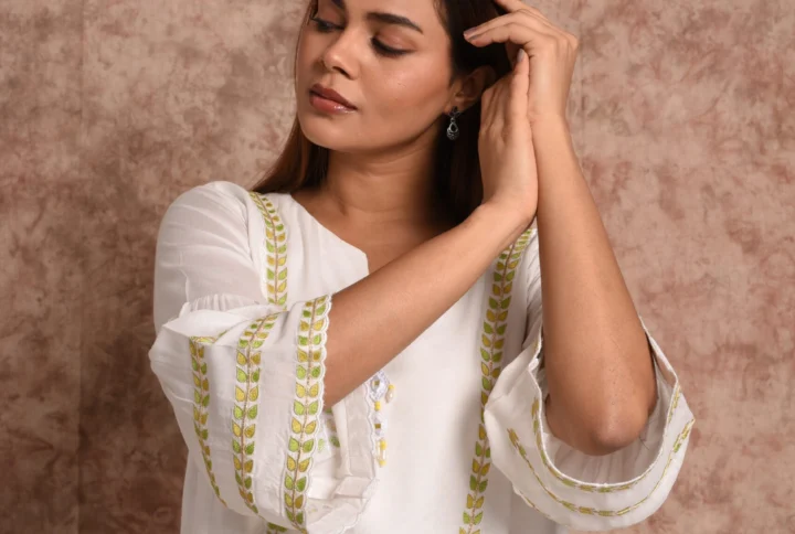 Front mid-shot of Solana white and gold sun embroidered A-line kurta top by EmbroWhite
