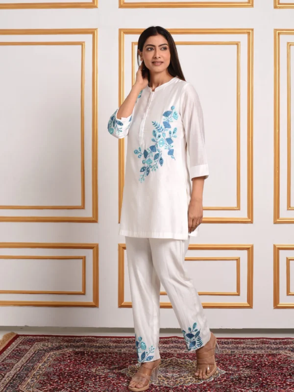 Full-length catalog view of Cyanne white tunic and trouser co-ord set showcasing cerulean blue floral threadwork by Embrowhite