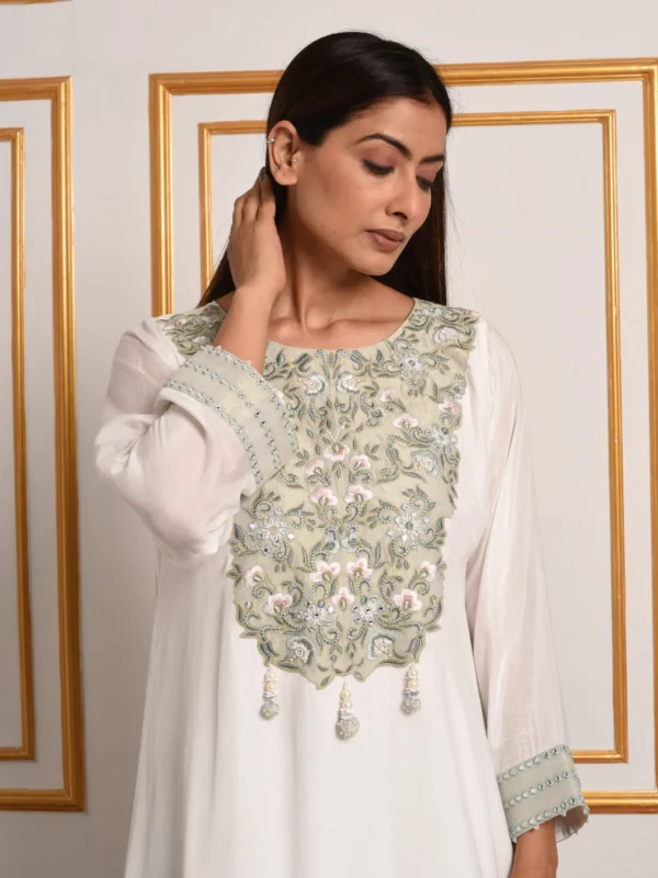 Full-length front catalog shot of Hinaya ivory and mint suit set with dupatta featuring floral yoke embroidery and tassel accents by Embrowhite