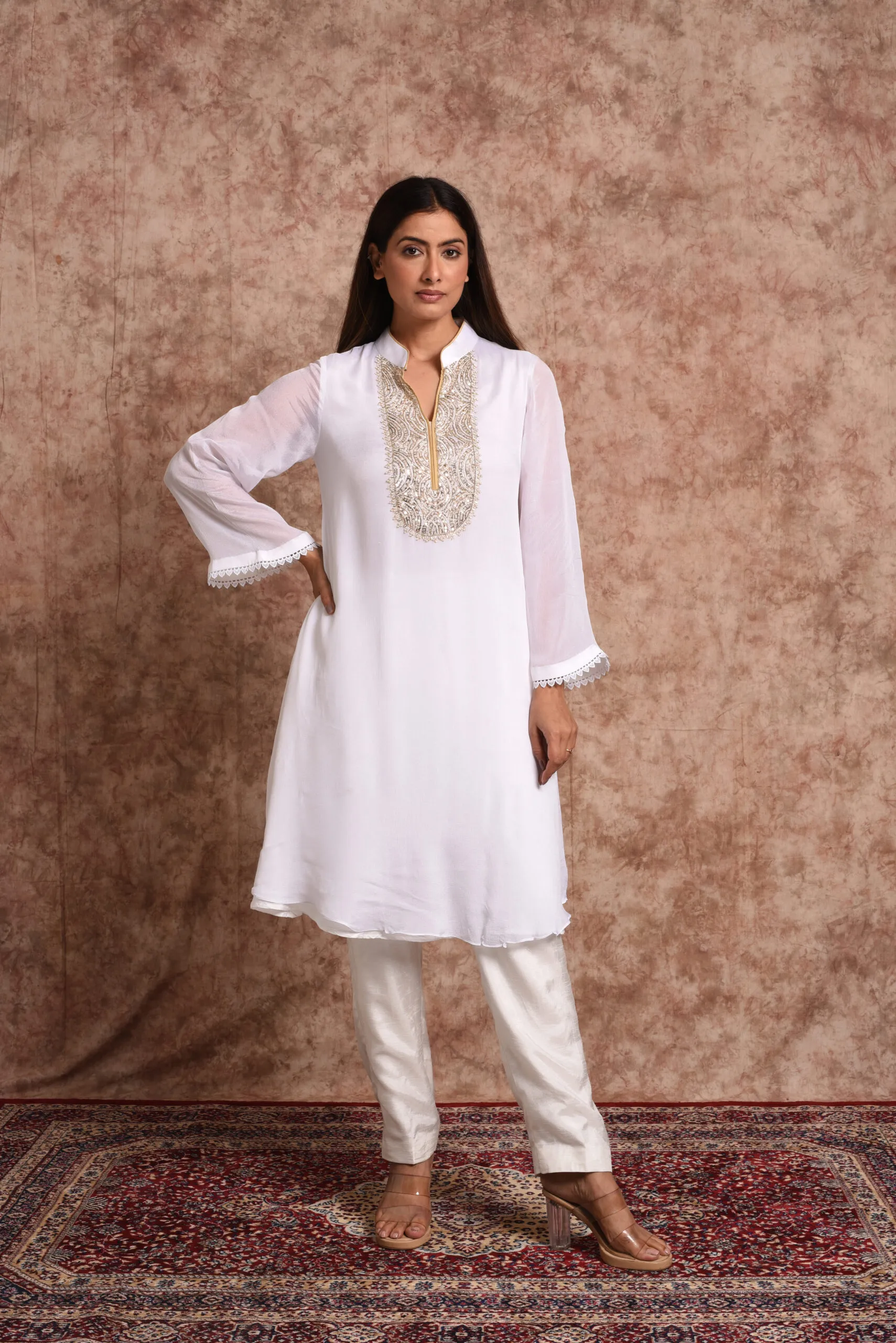Full-length front view of Starlight ivory mirrorwork kurta set featuring gold embroidered neck bib and straight pants by Embrowhite Full-length front view of Starlight ivory mirrorwork kurta set featuring gold embroidered neck bib and straight pants by Embrowhite