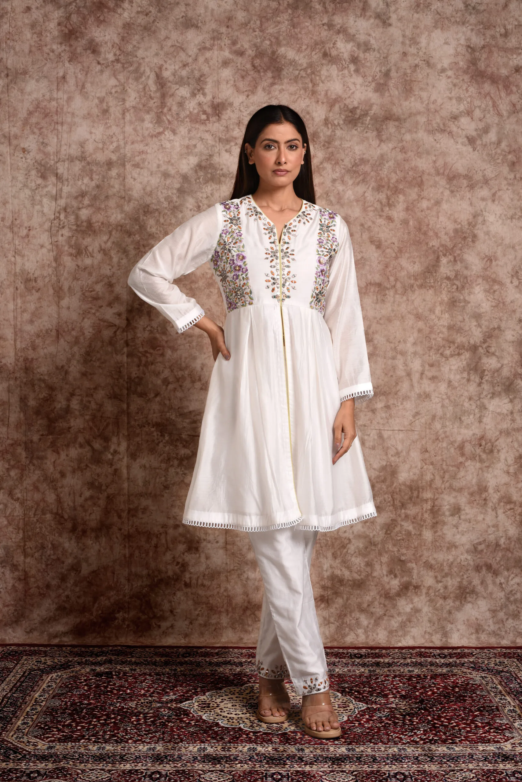 Full-length view of Gulistan ivory flared front-slit kurta paired with embroidered-hem straight pants by Embrowhite Full-length view of Gulistan ivory flared front-slit kurta paired with embroidered-hem straight pants by Embrowhite