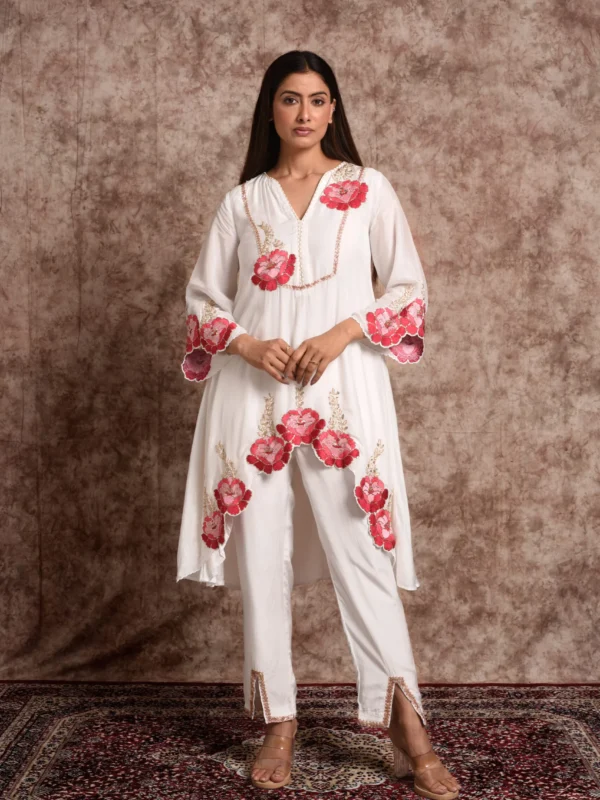 Full-length view of Roselle ivory high-low embroidered kurta with matching straight trousers featuring front slits by Embrowhite