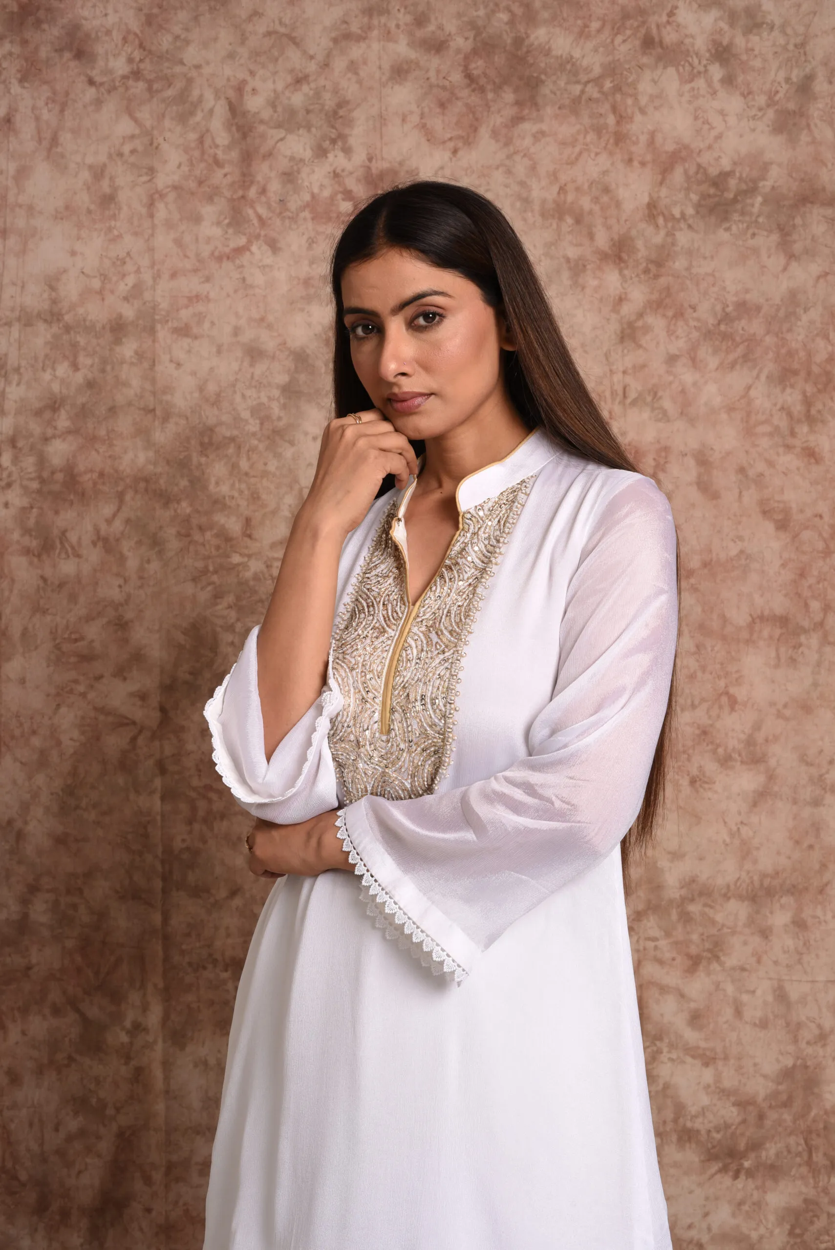 Medium portrait shot of model wearing Starlight ivory mirrorwork kurta showing bell sleeves with lace trim by Embrowhite Medium portrait shot of model wearing Starlight ivory mirrorwork kurta showing bell sleeves with lace trim by Embrowhite