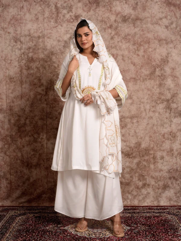Model styling Solana white kurta palazzo suit set with embroidered scalloped dupatta worn over head by EmbroWhite