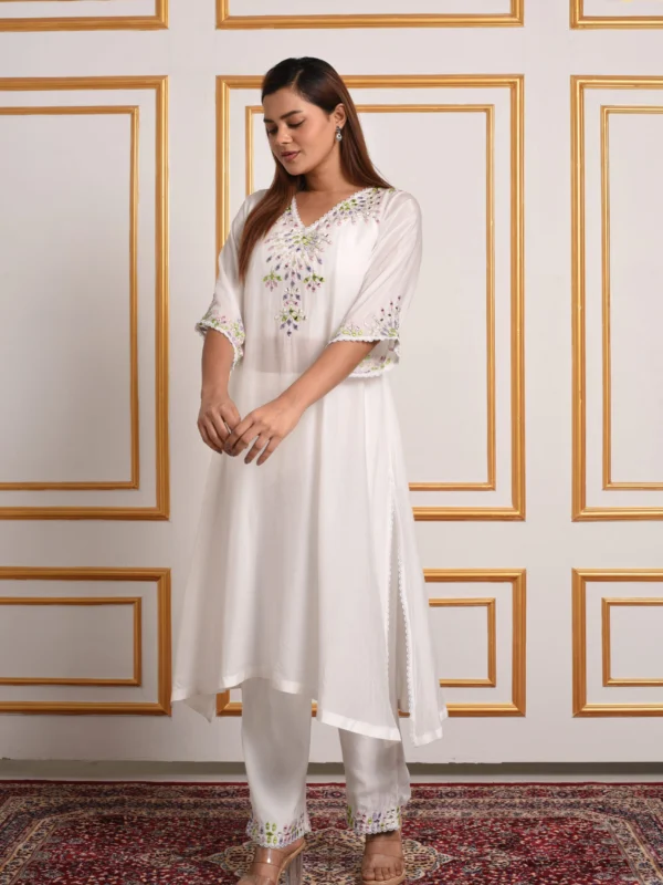 Side profile of Iris White flared A-line kurta and pants set with scalloped side slits by Embrowhite