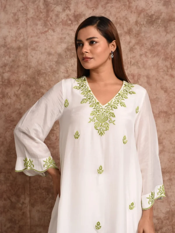 Three-quarter portrait shot of model wearing Kashvi off-white tunic showing green folk-art embroidery by Embrowhite