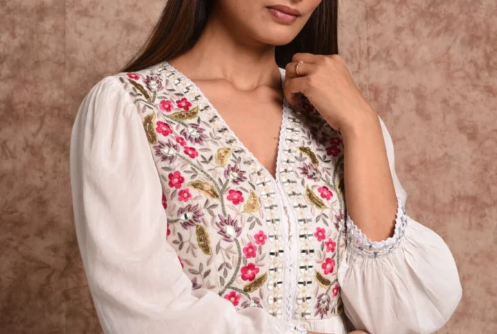 Close up detail of hand embroidered floral V-neck bodice on Zinnia ivory front open tunic by EmbroWhite
