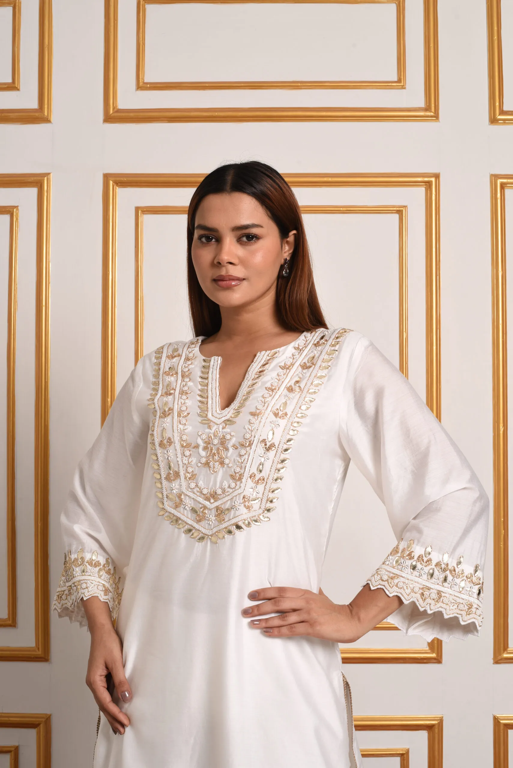 Close up of EmbroWhite ivory kurta featuring gold embroidery on scalloped sleeve borders Close up of EmbroWhite ivory kurta featuring gold embroidery on scalloped sleeve borders