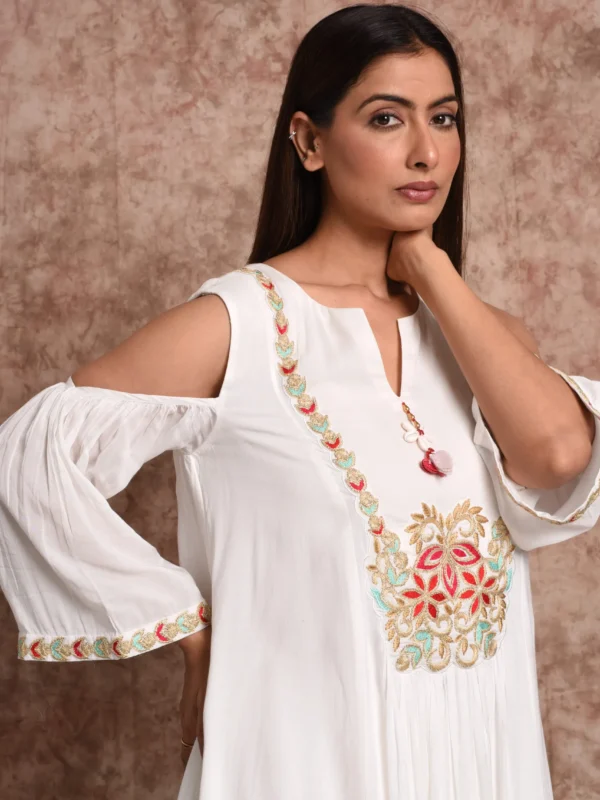 Close-up of vibrant floral neck embroidery and tassel string on Aamani white tunic by Embrowhite