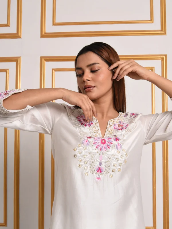 Close up view of EmbroWhite Gul-Dasta ivory silk kurta chest featuring pink and silver embroidery
