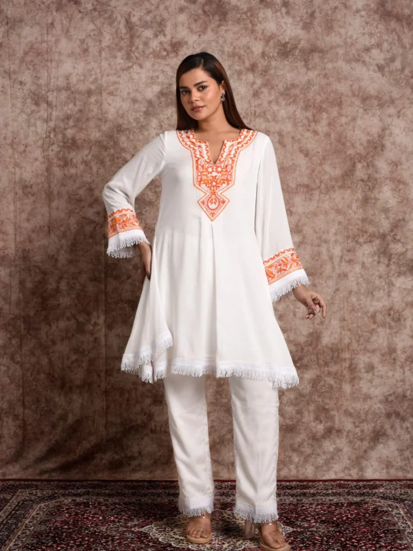 Front view of model in EmbroWhite Floriana ivory short kurta set with orange embroidery