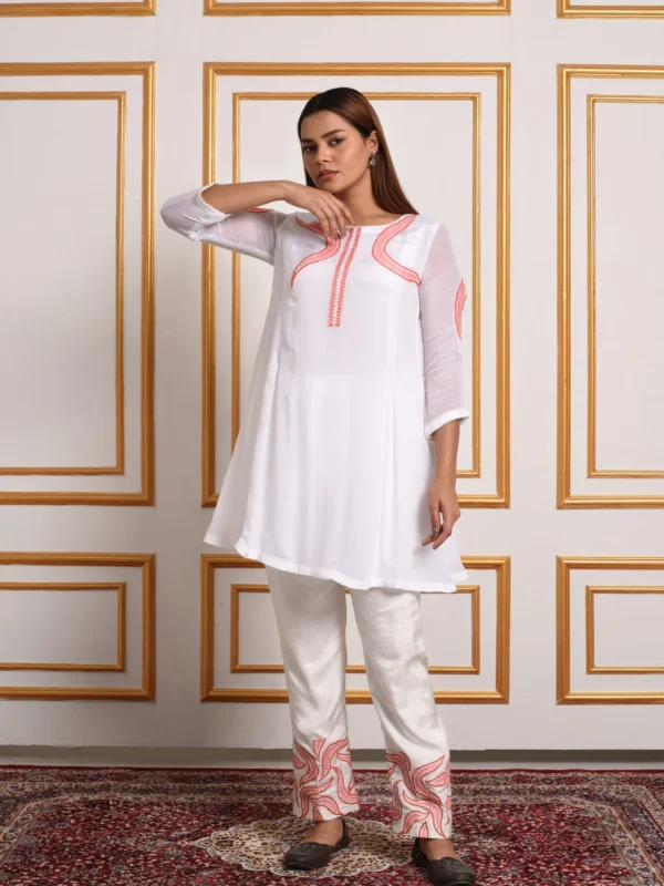 Full-length catalog view of Aira white flared tunic co-ord set with coral peach vine embroidery on neckline and pants by Embrowhite