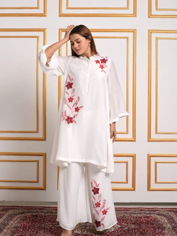 Full length front pose of model in EmbroWhite Amara white embroidered A-line tunic paired with embroidered palazzo pants