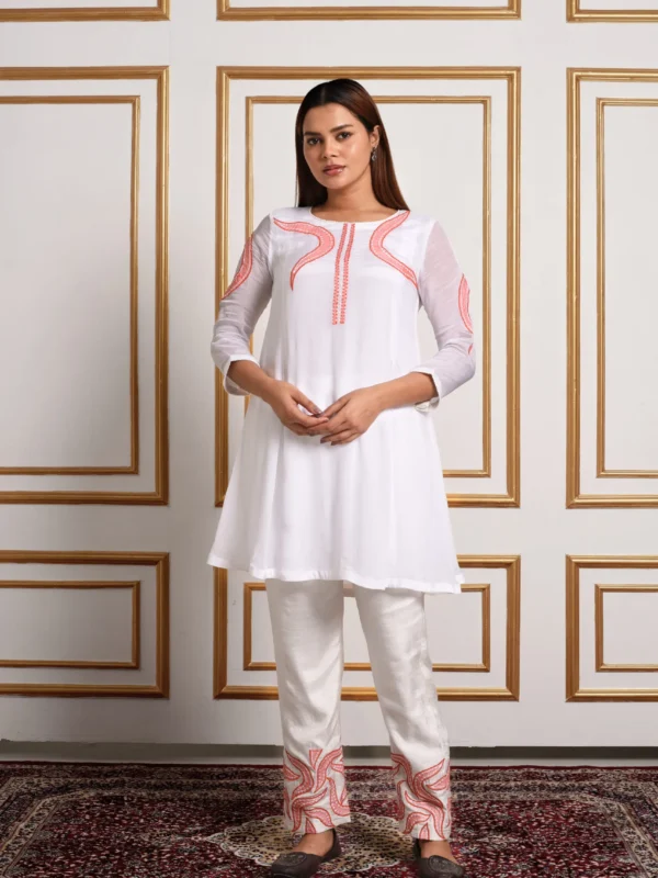 Full-length front view of Aira white co-ord set featuring coral peach vine embroidery on tunic and straight pants by Embrowhite