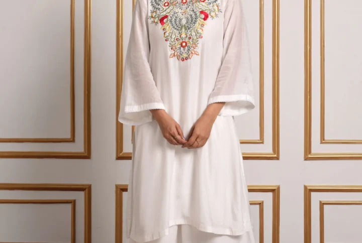 Full-length front view of Iris off-white kurta with palazzo set featuring pastel floral mosaic bib embroidery and bell sleeves by Embrowhite