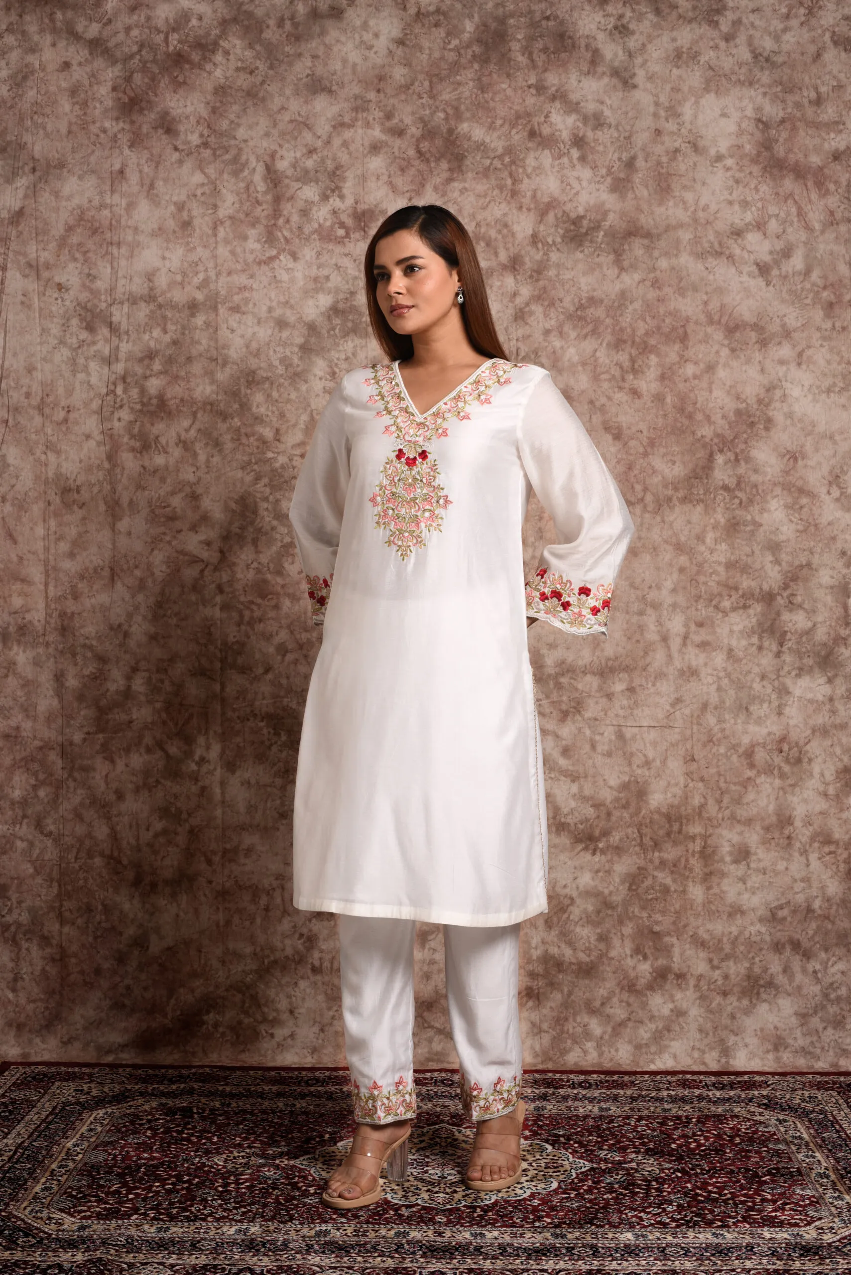 Full length front view of model wearing EmbroWhite Zoya white silk kurta with red floral embroidered yoke and hemmed trousers Full length front view of model wearing EmbroWhite Zoya white silk kurta with red floral embroidered yoke and hemmed trousers