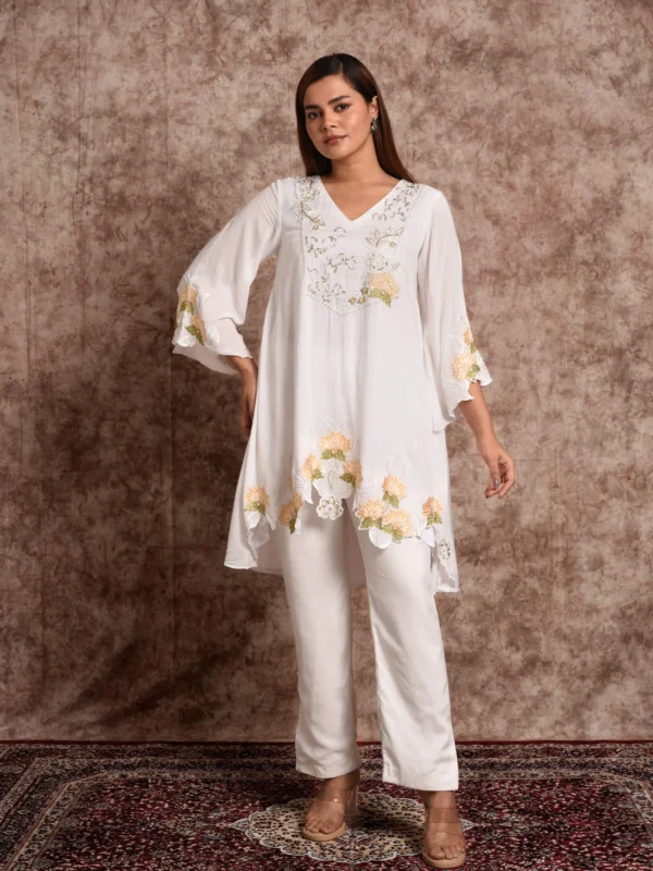 Full-length view of Zora white high-low asymmetric tunic with matching straight trousers by Embrowhite