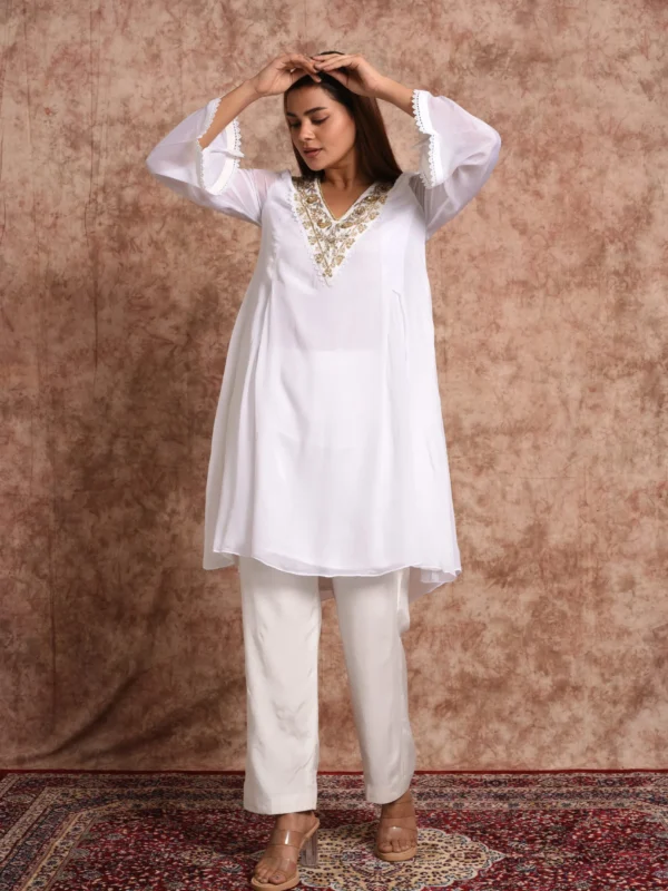 Full-length view of model in Pure Bloom Gilded white short kurta set with gold V-neck hand embroidery and lace cuffs by Embrowhite