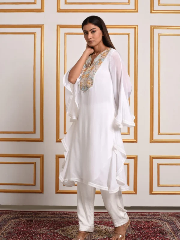 Medium close-up shot of Solana off-white tunic displaying wide flared bell sleeves and gold embroidery by Embrowhite