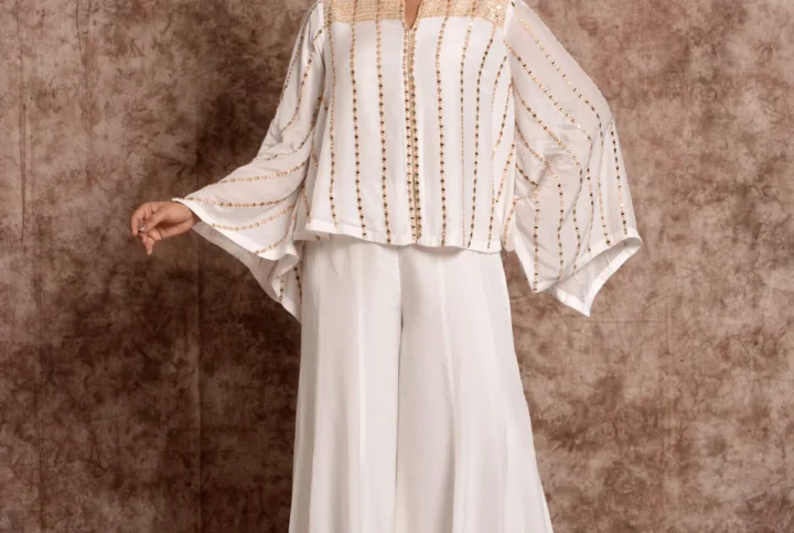 Model posing in EmbroWhite white embellished kaftan top and wide-leg palazzo pants