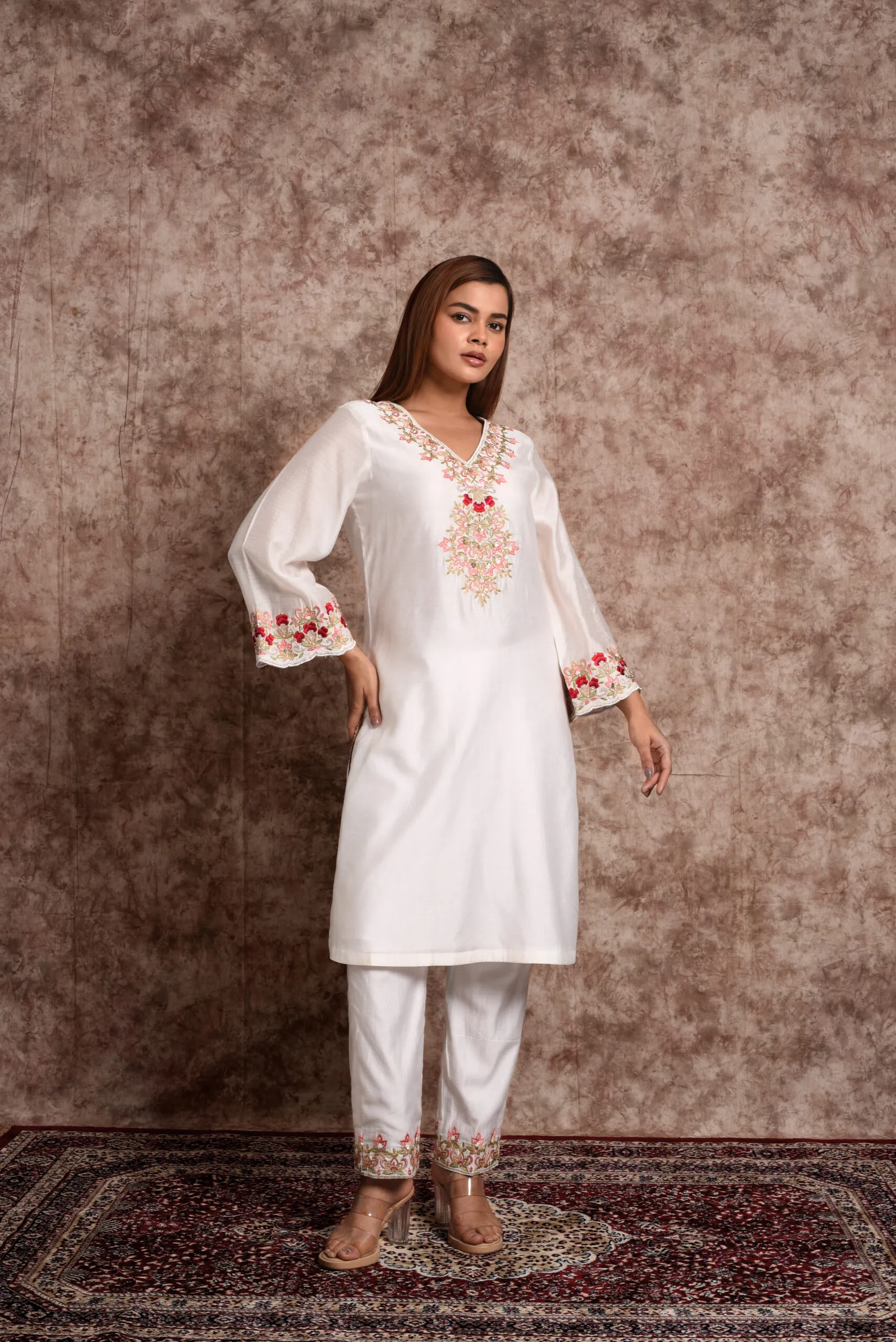Model standing in three-quarter pose wearing EmbroWhite Zoya white kurta set with embroidered bell sleeves Model standing in three-quarter pose wearing EmbroWhite Zoya white kurta set with embroidered bell sleeves