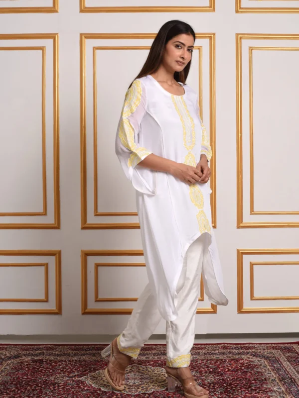Side view of model walking in Meher Jade Botanical white asymmetrical tunic kurta co-ord set with yellow embroidery by Embrowhite