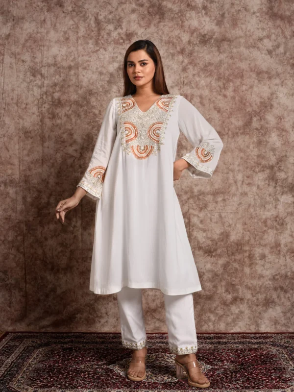 Standing pose of model in EmbroWhite Zaira ivory silk kurta set with embroidered bell-style cuffs