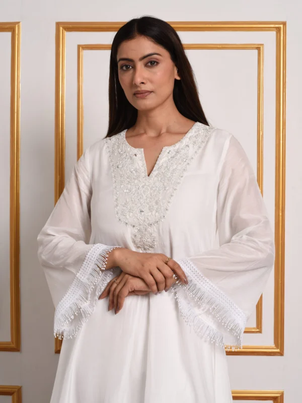 Wide bell sleeves and fringe detailing on the Embrowhite Sunset Bouquet Heritage White Kurti Set